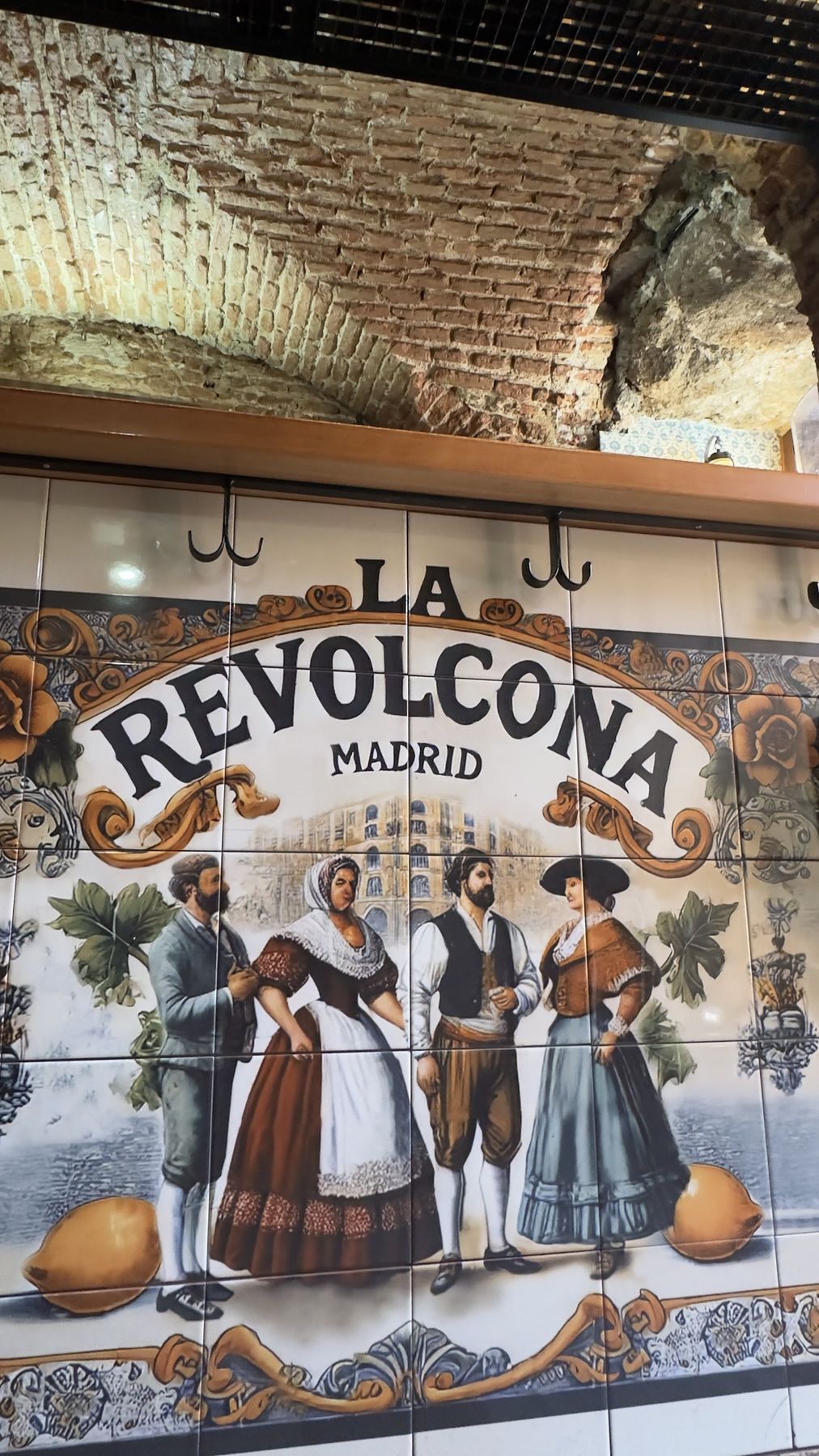 Tiled mural reading “La Revolcona, Madrid” with traditional Madrid figures